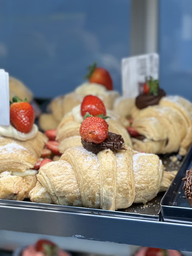 Croissants com morango e chocolate na vitrine da padaria