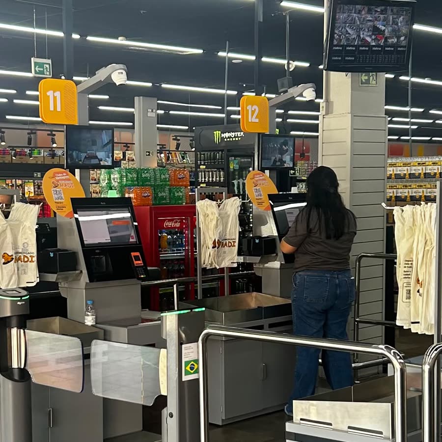 Terminais de autoatendimento da loja da Avenida dos Estados, com uma cliente passando as compras